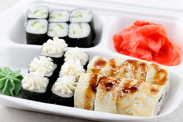 Sushi roll set in a white box. A lot of different sushi with wasabi and ginger. Ready order in a sushi bar.