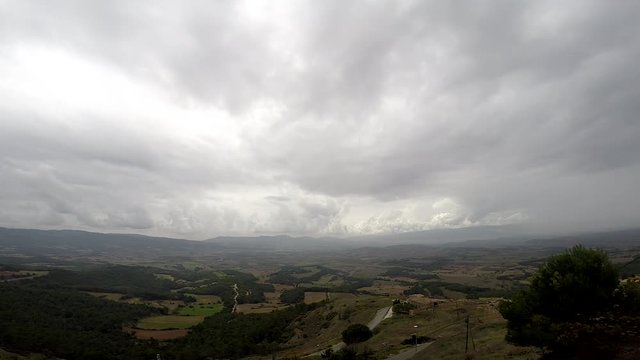 Timelapse de nuves sobre unas vistas de campos con monta&ntilde;as de fondo