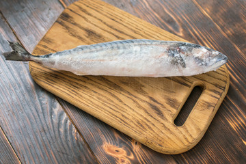 Frozen mackerel fish on wooden background.