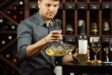 Sommelier holding decanter in hands full of wine