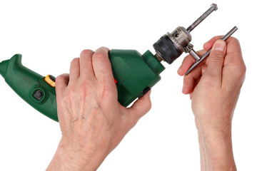 Elderly male home master replaces drill in comact electric drilling machine. Isolated