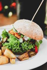 Vegan burger with lettuce, tomatoe, fried potatoes and garlic dill sauce
