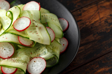 Fresh cucumbers, radish salad with salt, pepper and lemon