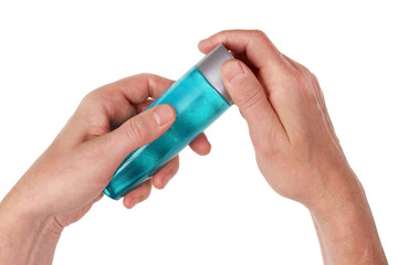 The old man opens a plastic bottle with shampoo to wash his head. Isolated