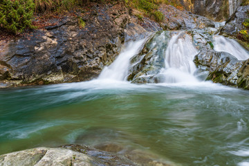 Fototapeta premium Waterfall and autumn colors. Magic of the Julian pre-Alps.