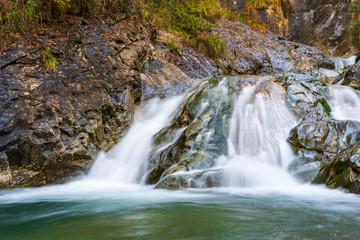 Fototapeta na wymiar Waterfall and autumn colors. Magic of the Julian pre-Alps.