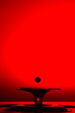 Closeup shot of splash of transparent liquid on red background