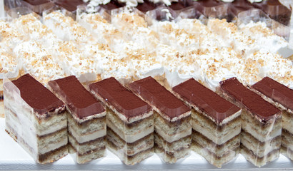  cake with cream filling stand in a row on the table for a banquet