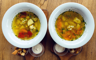 two white plates with soup