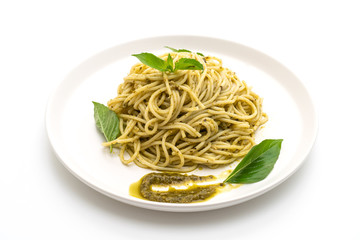 spaghetti with pesto sauce, olive oil and basil leaves.