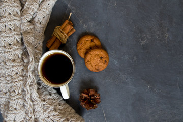 Winter composition. Cup of coffee, cookie, lights on a dark background. Flat lay