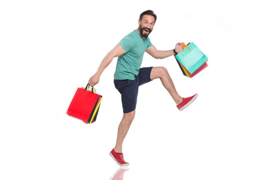 Excited man making big steps while carrying his wonderful purchases