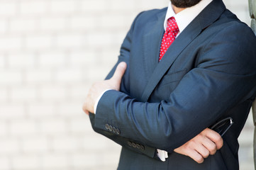 Close up of elegant man standing with his arms crossed