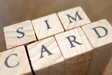 Wooden Text Block of SIM Card and real SIM cards.
