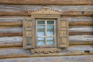 A small window with shutters of an old wooden house close up. Verhnie Mandrogi, Russia