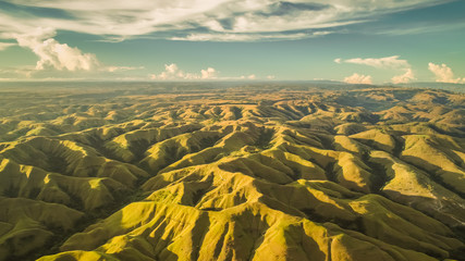 Luchtpanorama groene heuvels. Drone geschoten. Indonesië. Adembenemend landschap heuvelachtig oppervlak op de blauwe bewolkte hemelachtergrond. Sumba eiland. Prachtige schoonheid van de wilde ongerepte natuur.