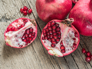 Ripe red fresh pomegranate fruit on wooden rustic background. Healthy food, closeup, flat lay, top view