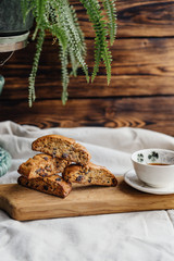 Italian biscotti cookies with a cup of black tea on a wooden board and wooden background. cozy photo