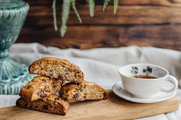 Italian biscotti cookies with a cup of black tea on a wooden board and wooden background. cozy photo