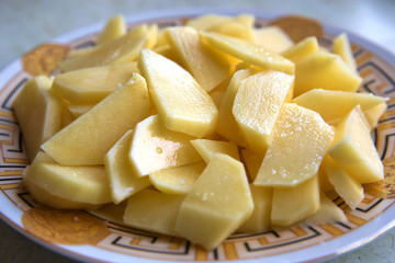 Chopped potatoes. In the chopped potato plate . Sliced, peeled raw potatoes on a board . Chopped potatoes in a bowl . Diced potatoes - as an ingredient to a potato based dish