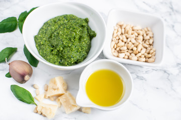 Homemade Classic Green Pesto Sauce in While Bowl with Pine Nuts Parmesan Cheese Garlic Olive Oil Italy Healthy Food Concept