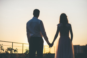 Bride and groom holding hands silhouette