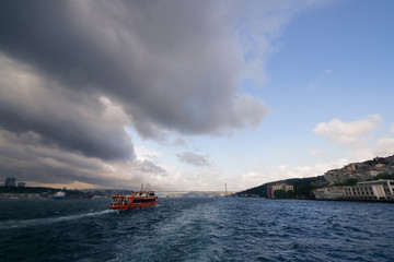 Bosphorus sea view with boat ship and 15 July Martyrs bridge or first bridge famous historical and cultural heritage cityscape