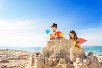 Fototapeta premium Boy and girl building sand castle at the seaside