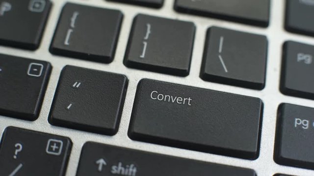 Convert button on computer keyboard, female hand fingers press key