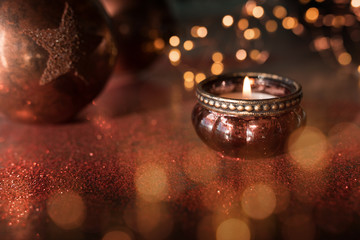 Candlelight with christmas balls and golden bokeh