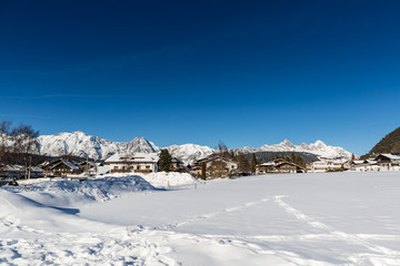 Seefeld village view over snowy field on sunny winter day