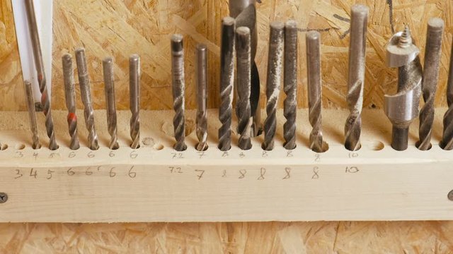 Drills of different sizes in the workshop. Set of drill bits stand in a row.
