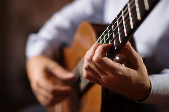 Close up of guitarist hand on classical guitar. Selective focus, shallow depth of field.
