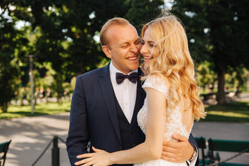 Groom smile to his bride and hud her. Just Married couple