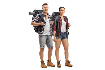 Male and female hikers with backpacks standing and looking at the camera