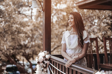 woman in Thai traditional dress at wooden house