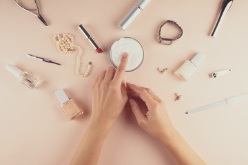 Skin care concept. Woman applying hand cream on puffy background. Flat lay. Top view. Toned