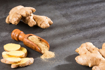 Fresh ginger root and ground ginger spice - Zingiber officinale. Wooden spoon