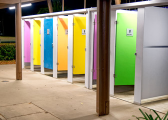 Colorful WC cabins at night in a city square