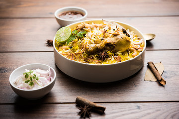 Delicious spicy chicken biryani in bowl over moody background, it’s a popular Indian and Pakistani food.