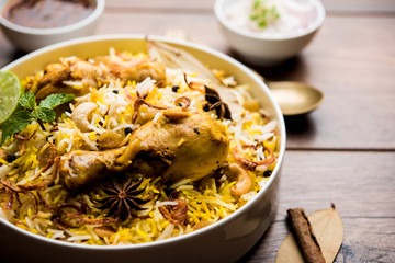 Delicious spicy chicken biryani in bowl over moody background, it’s a popular Indian and Pakistani food.