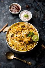 Delicious spicy chicken biryani in bowl over moody background, it’s a popular Indian and Pakistani food.