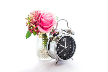 Artificial plastic flowers and clock isolated on white background.