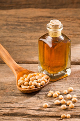 Oil and soybeans - Glycine max. Wooden background