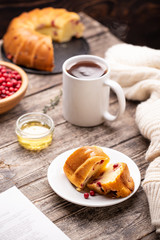 Cranberry bundt (wreath) cake served on white plate with tea mug and honey