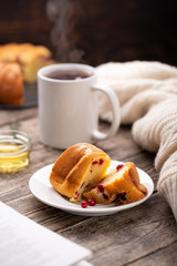 Cranberry bundt (wreath) cake served on white plate with tea mug and honey