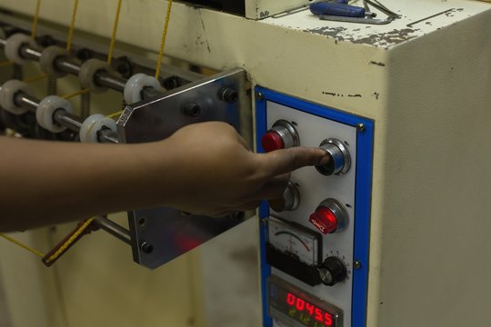 Worker operating loom machine in rope making industry