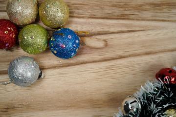 Christmas decoration on wooden textured background. Ornaments arranged creatively around the borders with fir leaves. Seasons greetings. Flat lay or top view.