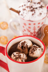 Cup with hot chocolate and marshmallows on old wooden table.