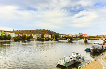 City view from bridge and traditional Czech architecture of antique Prague buildings at autumn evening.